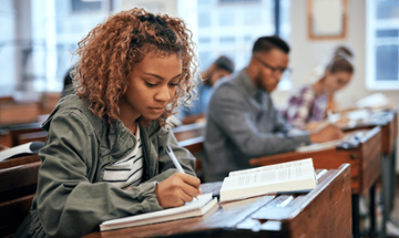 female student writing at a desk