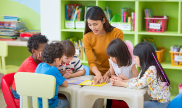 elementary ed teacher with students at a table