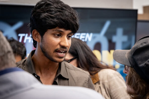 A student speaks with other attendees during the November 5, 2025 AI & Quantum Innovation Lab pitch event at CUW.