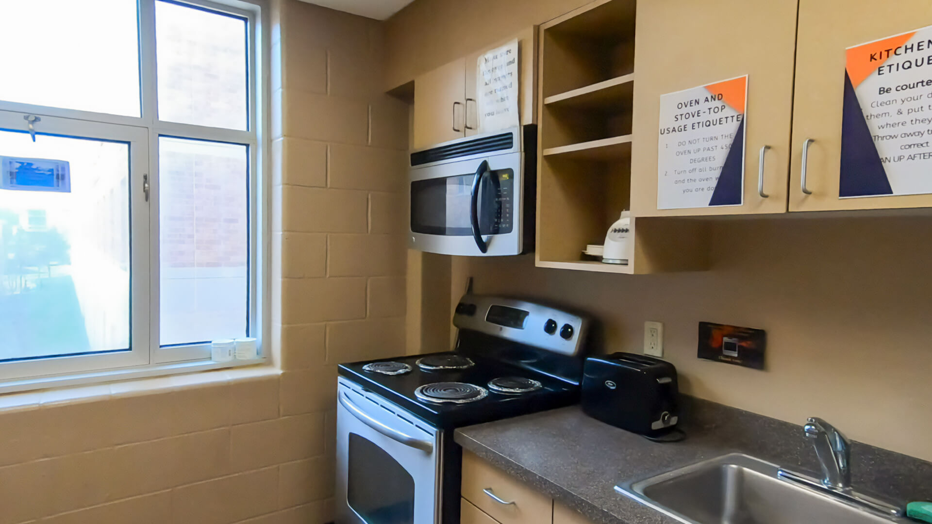 A Coburg kitchen complete with stove, toaster, sink, and microwave.