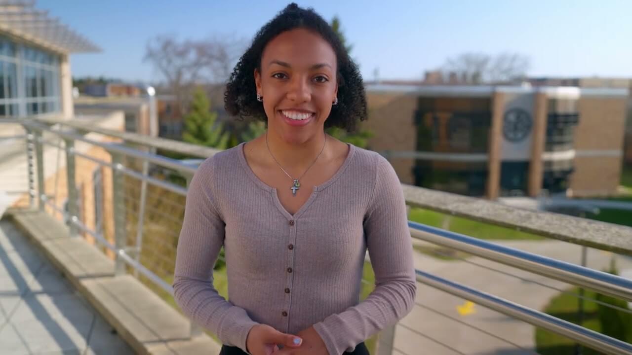 Sabrina Moore, CUW occupational therapy student, smiles on the School of Pharmacy balcony overlooking the Interprofessional Clinic.