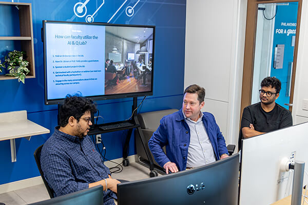 Students and faculty collaborating at computer monitors inside the AI & Quantum Innovation Lab at Concordia University Wisconsin.